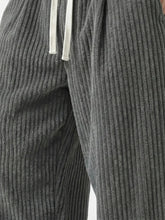 Zoom sur le tissu du pantalon japonais homme Akeno, matière plissée verticale gris anthracite, texture douce et fluide, cordon de serrage visible