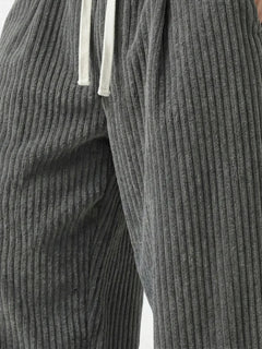 Zoom sur le tissu du pantalon japonais homme Akeno, matière plissée verticale gris anthracite, texture douce et fluide, cordon de serrage visible