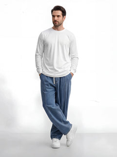 Pantalon japonais en jean pour homme vu de face, denim bleu, coupe ample et fluide, taille ajustable avec cordon, style minimaliste inspiré du Japon, silhouette moderne et décontractée.