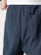 Détail des poches arrière sur pantalon style japonais homme bleu à coupe ample