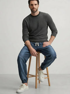 Pantalon style japonais homme bleu porté assis avec coupe ample et chevilles resserrées