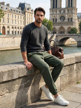 Pantalon style japonais homme vert porté assis en extérieur avec coupe ample et chevilles resserrées