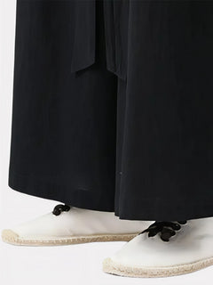 Zoom sur le bas du pantalon japonais noir, tissu fluide et finition droite avec coupe ample typique du style japonais.
