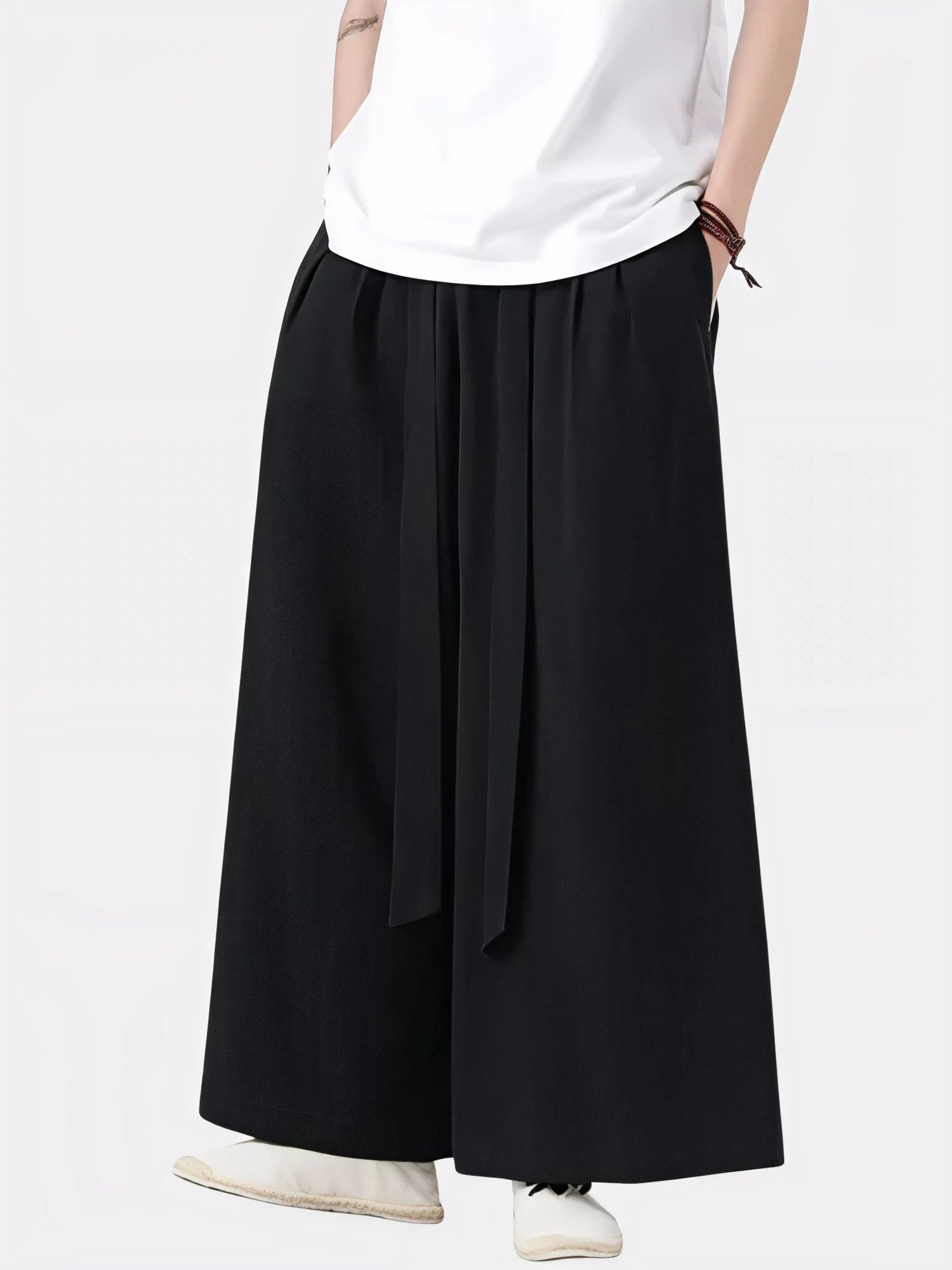 Homme portant un pantalon japonais noir à ceinture nouée, coupe ample et fluide inspirée du style zen japonais.