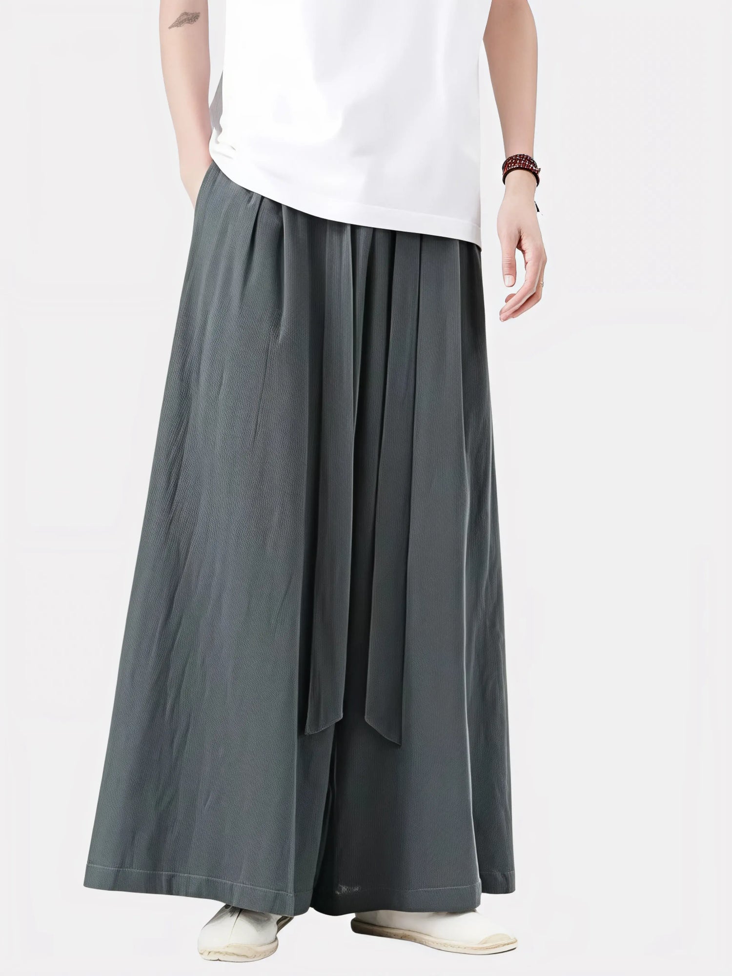 Homme portant le pantalon japonais Satori gris anthracite, coupe ample et ceinture longue nouée à la taille, inspiré du style zen et minimaliste japonais.