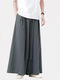 Homme portant le pantalon japonais Satori gris anthracite, coupe ample et ceinture longue nouée à la taille, inspiré du style zen et minimaliste japonais.