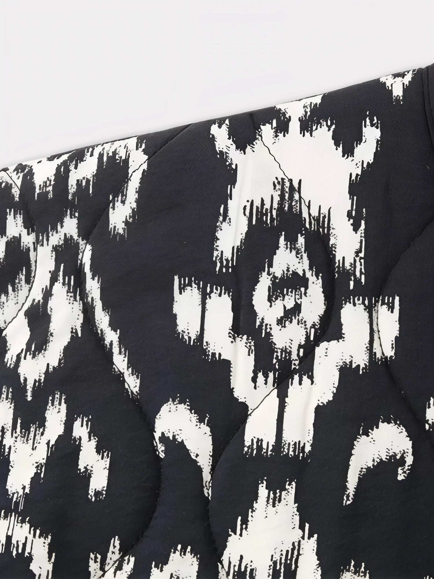 Zoom sur le motif ikat noir et blanc de la veste kimono matelassée Edo Pattern.